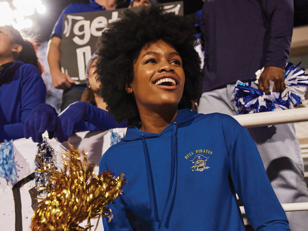 Woman in blue hoodie with pom-poms at a sports event