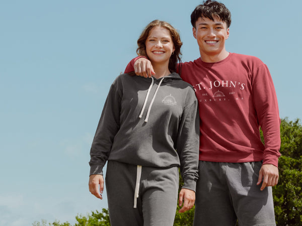 Two people wearing matching outfits with 'St. John's' branding outdoors.