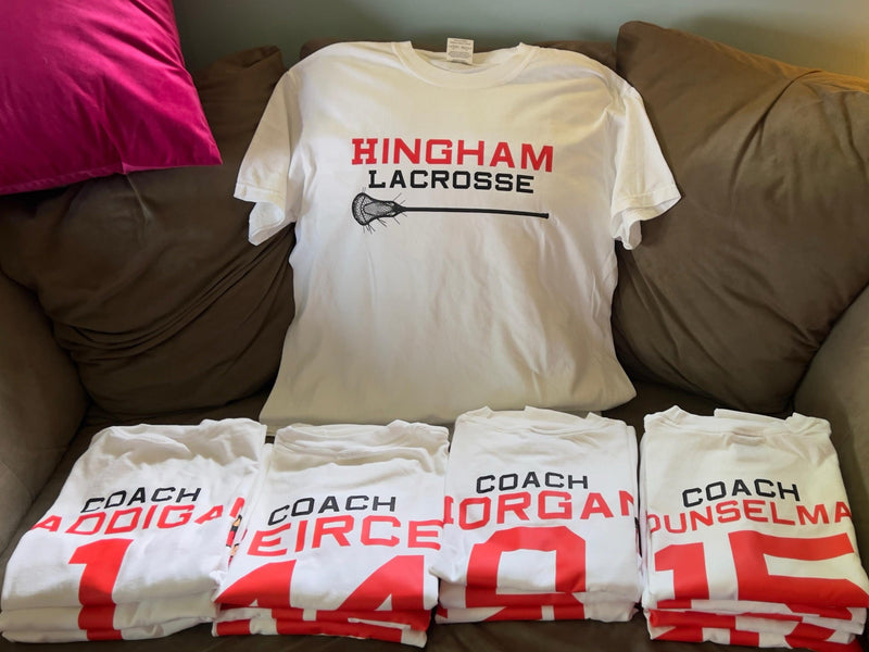 Collection of 'Hingham Lacrosse' and 'Coach' shirts on a couch.