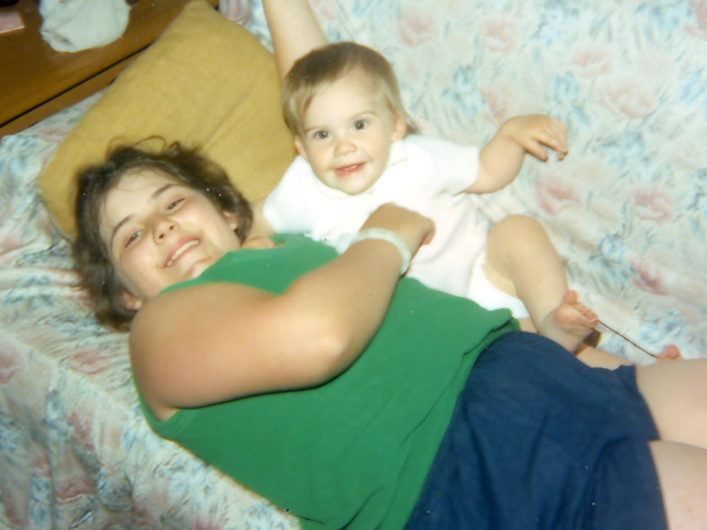Woman and child lying on a bed with floral bedding
