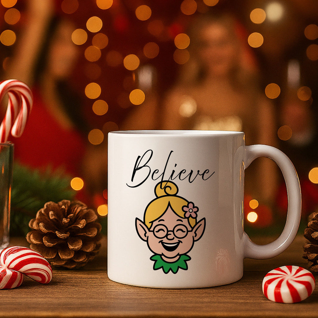 White mug with elf design and 'Believe' text on a festive background with candy canes and pinecones.