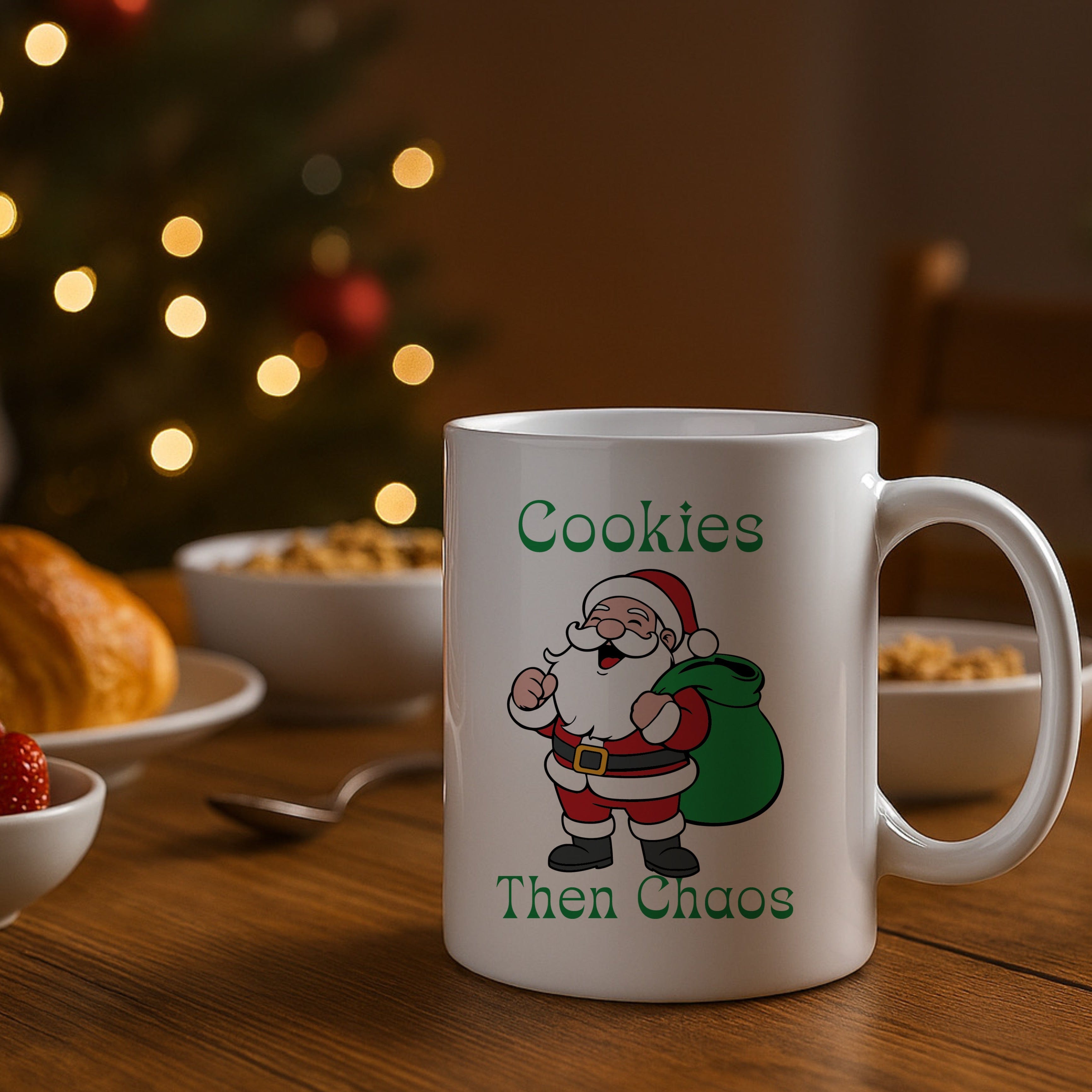 White mug with Santa Claus design and 'Cookies Then Chaos' text on a table with Christmas decorations.