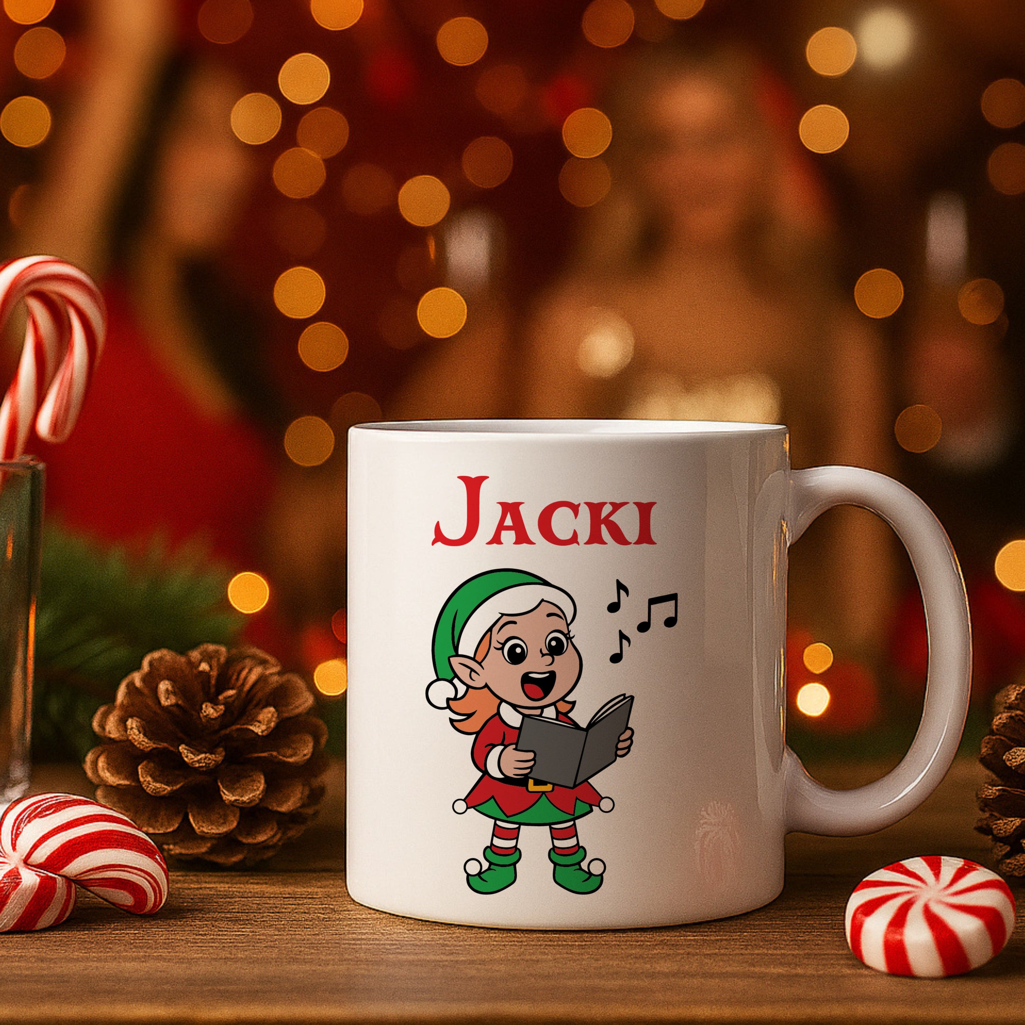 White mug with 'Jacki' and an elf design on a wooden surface with Christmas decorations.