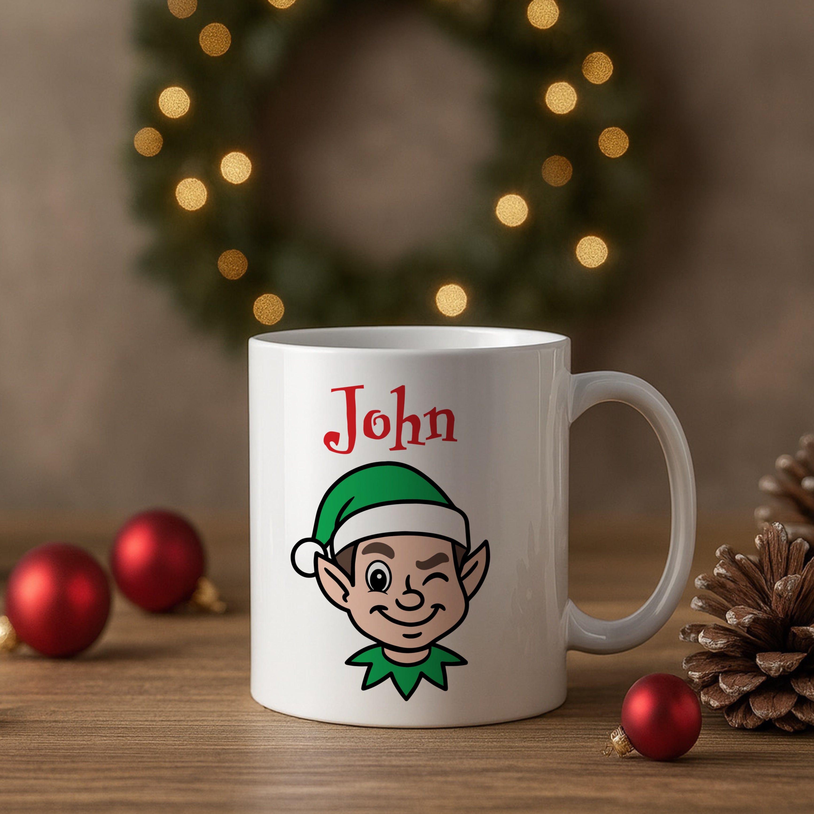 White mug with an elf design and 'John' text, placed on a wooden surface with Christmas decorations.