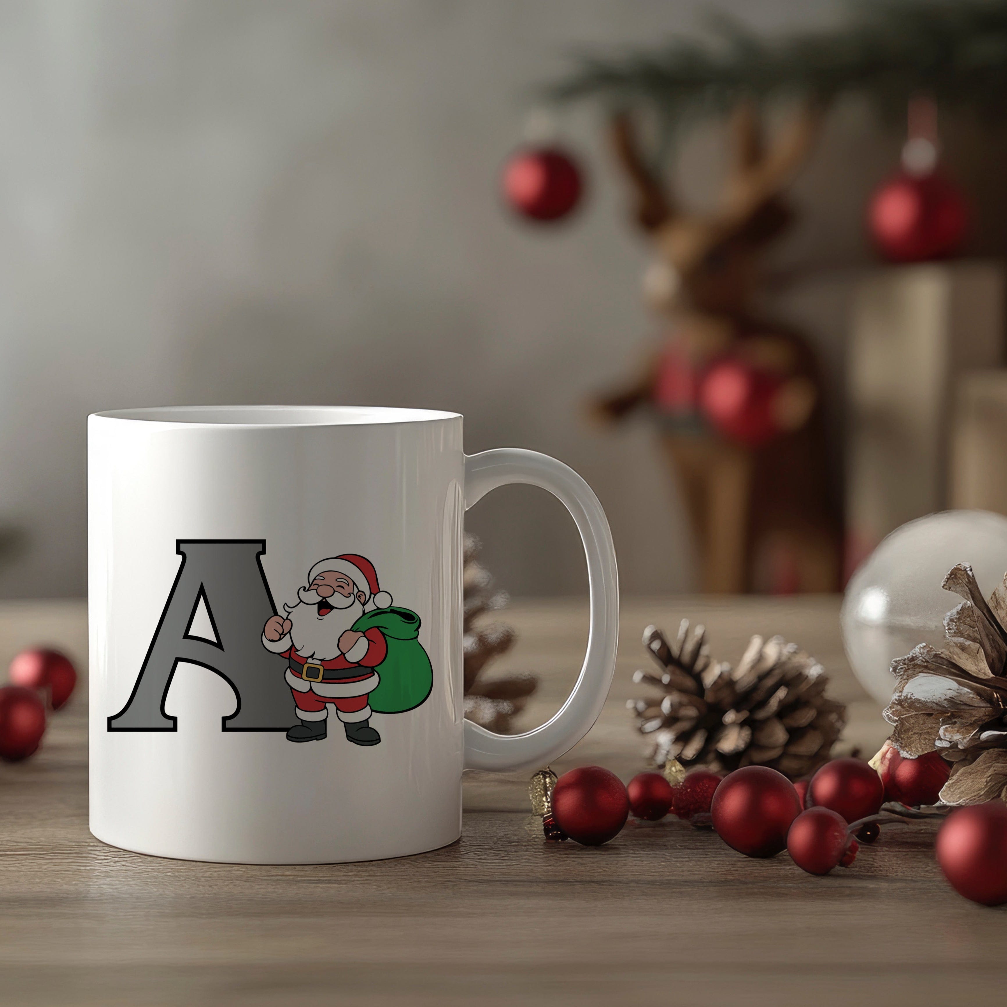 White mug with Santa Claus design and letter 'A' on a festive background with Christmas decorations.
