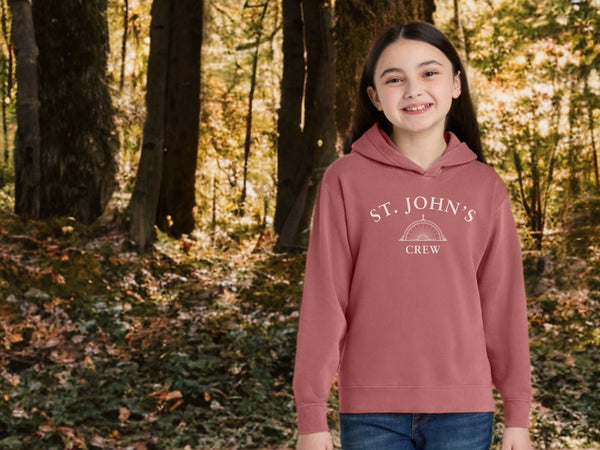 Person wearing a 'St. John's Crew' hoodie in a forest setting