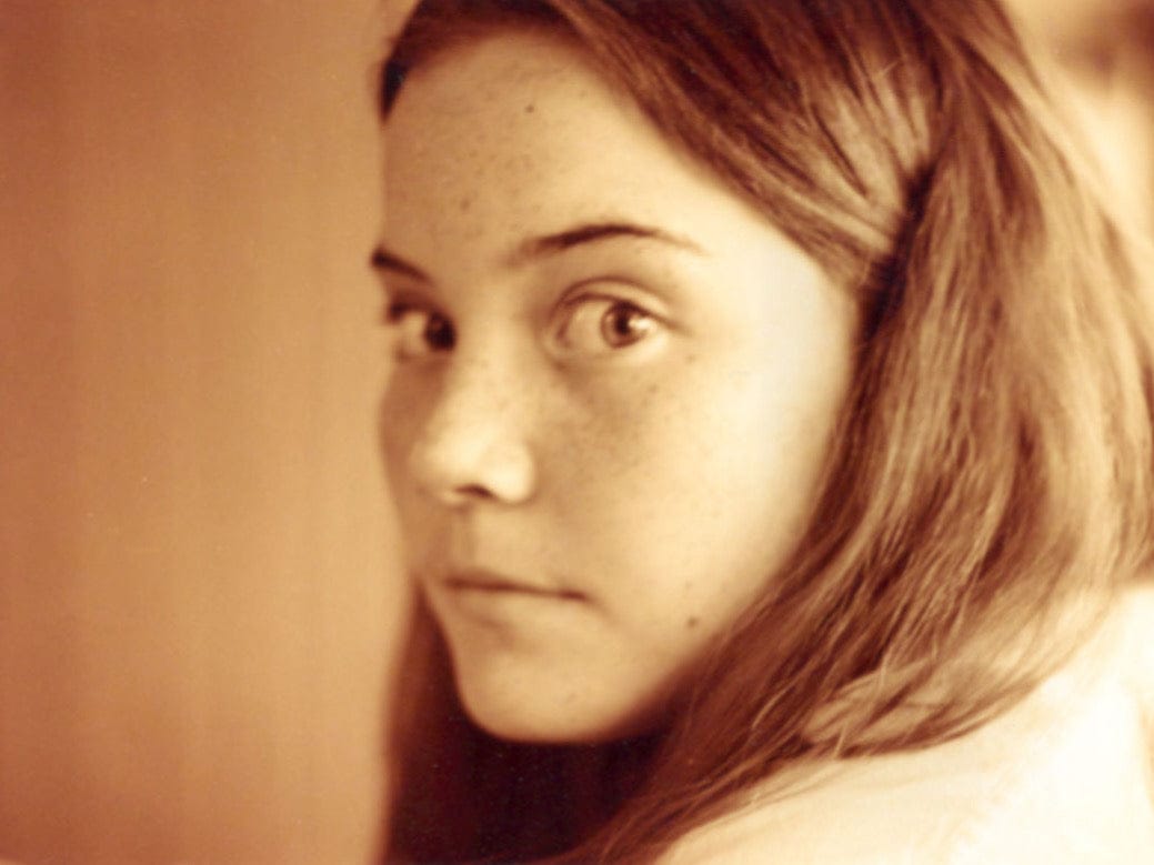 Close-up of a person with a neutral expression against a plain background